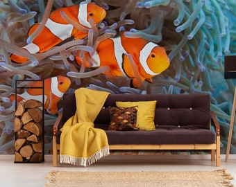 Könnte beinhalten: Ein braunes Sofa mit gelben Überwürfen und einem gemusterten Kissen steht vor einer Wandmalerei, die orangefarbene und weiße Clownfische zeigt, die in einem blauen und violetten Korallenriff schwimmen.
