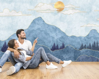 May include: A couple sits on a wooden floor in front of a blue and gold mountain landscape wall mural. The couple is looking up at the mural, which features a sun and clouds.