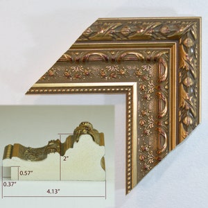 May include: A gold picture frame with an ornate design. The frame is 2 inches wide, 4.13 inches tall, and 0.57 inches deep.