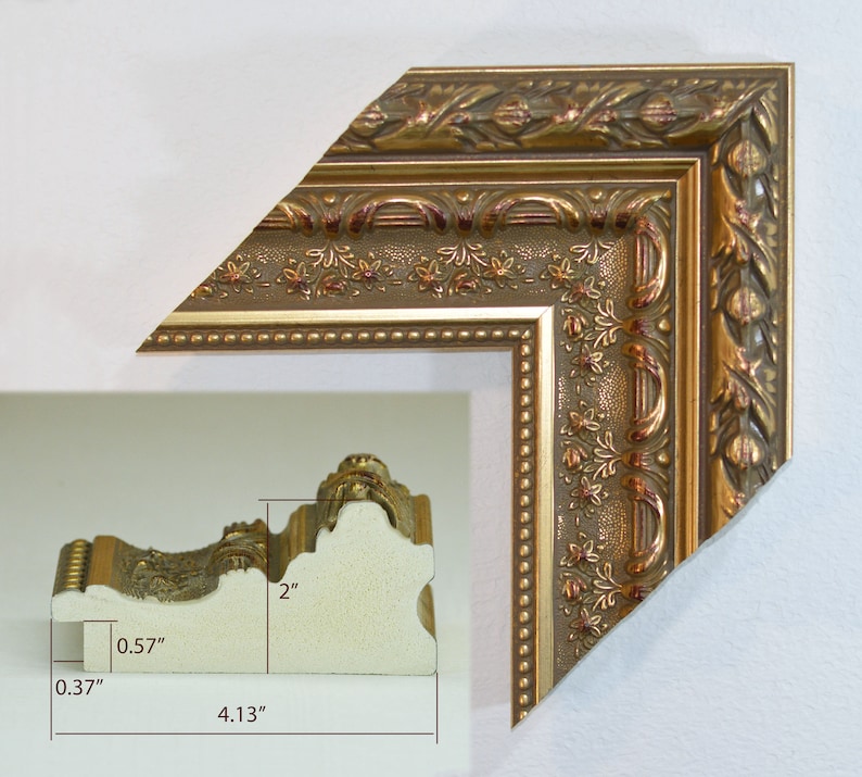 May include: A gold picture frame with an ornate design. The frame is 2 inches wide, 4.13 inches tall, and 0.57 inches deep.