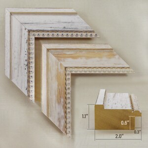 May include: Distressed white and cream-colored picture frame corner samples. The frame has a beaded edge and measures 2.0 inches wide, 1.1 inches high, and 0.6 inches deep. The frame has a rustic, weathered appearance.