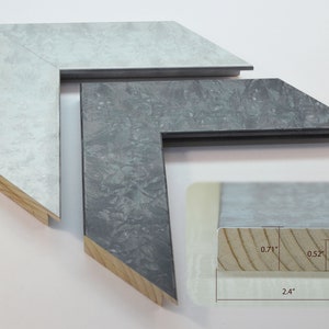 May include: Two picture frames with a silver and gray finish. The frames are made of wood and have a beveled edge. The frames are 2.4 inches wide, 0.71 inches tall, and 0.52 inches deep.