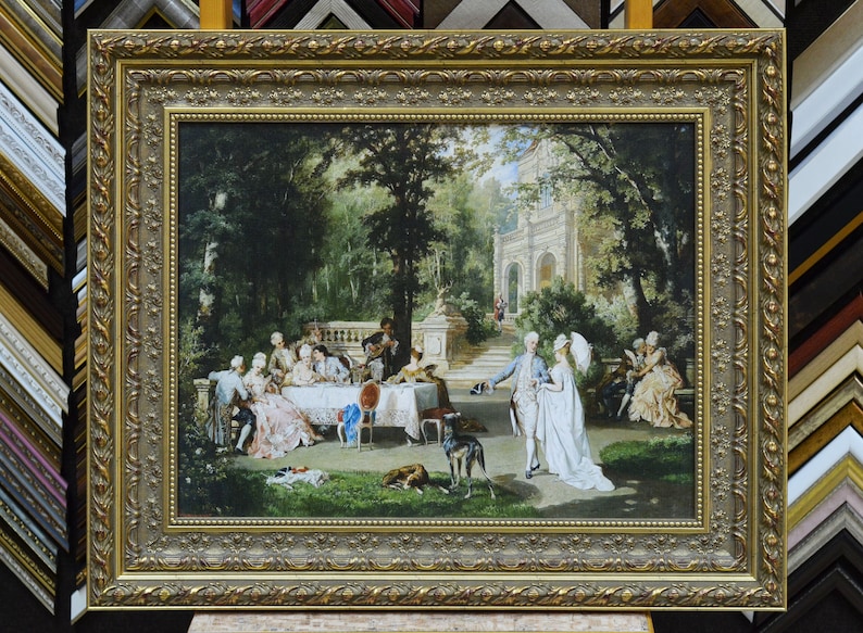 May include: A framed oil painting depicting a group of people gathered in a garden setting. The scene features a large group of people in 18th-century clothing, enjoying a meal outdoors. There are trees, a building, and a dog in the background.