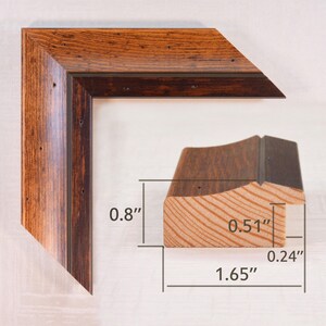 May include: A corner section of a wooden picture frame with a dark brown finish. The frame is 0.8 inches wide, 0.51 inches deep, and 1.65 inches across. The wood grain is visible, and the frame has a rustic appearance.