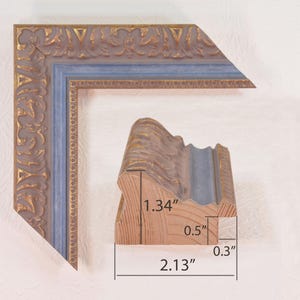 May include: A blue and gold picture frame with ornate detailing. The frame is 1.34 inches wide, 2.13 inches tall, and 0.5 inches deep.
