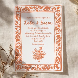 May include: A wedding invitation with an orange floral border. The invitation reads "Together with their families Lola & Grem Invite you to celebrate their marriage on Saturday, October twentieth two thousand twenty four at five o'clock Red Hill Boise, Idaho"