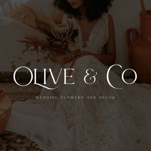 May include: A bride wearing a white lace dress holds a bouquet of dried flowers. The text "Olive & Co. Wedding Flowers and Decor" is displayed below the image.