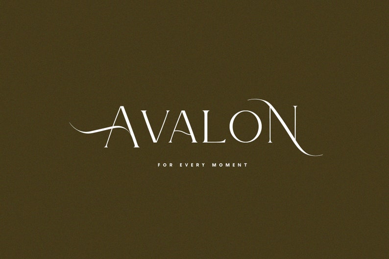 May include: White text on a brown background reads "AVALON" in a script font with a flourish on the "A" and "N". Below the text is "FOR EVERY MOMENT" in a smaller font.