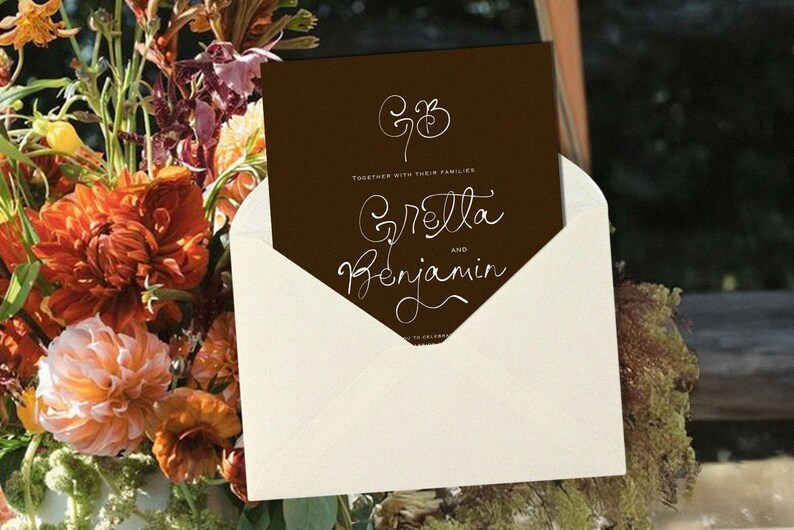 May include: A wedding invitation card in a cream envelope. The dark brown card features white calligraphy with the names Gretta and Benjamin. The invitation is set against a backdrop of colorful flowers, including orange dahlias.