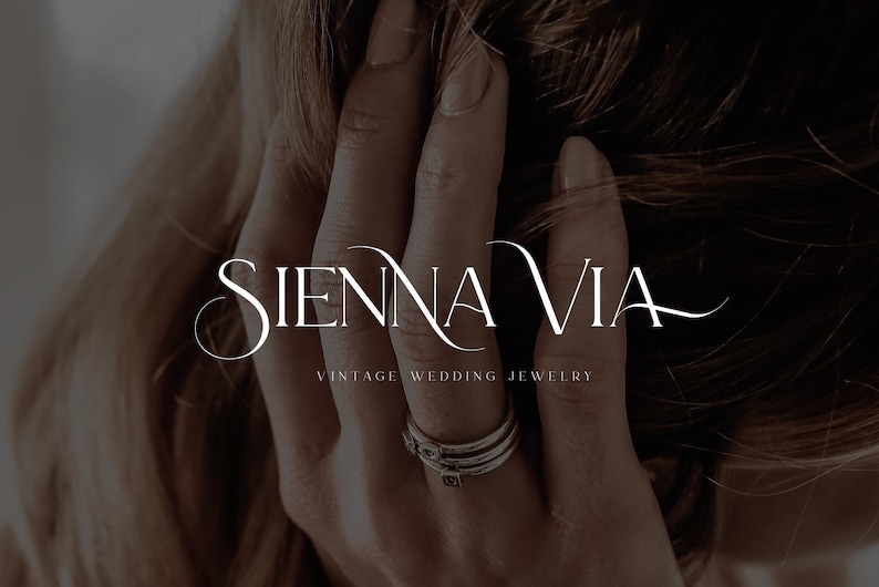 May include: A close-up of a hand wearing a stack of silver rings with a simple design. The text "SIENNA VIA VINTAGE WEDDING JEWELRY" is displayed below the hand.