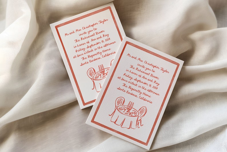 May include: A red and white invitation card with a red border. The card is for a rehearsal dinner in honor of Ann and Ray. The card features a hand-drawn illustration of a table setting with candles and a plate of food. The text on the card reads: "Mr and Mrs. Christopher Taylor invite you to The Rehearsal Dinner in honor of Ann and Ray Friday, September 18, 2014 at four o'clock in the afternoon The Pagaretty Home Santa Barbara, California"