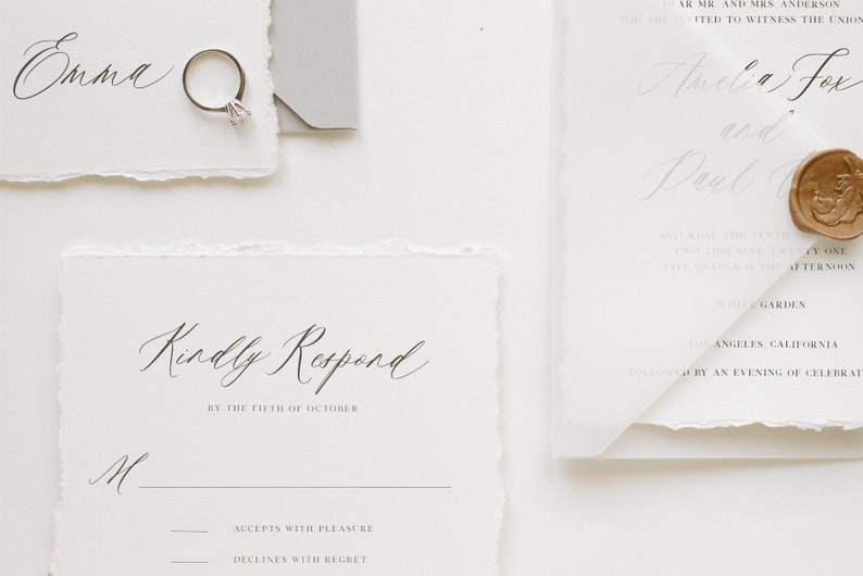 May include: A white RSVP card with a handwritten message that reads "Kindly Respond by the Fifth of October". The card has two options for guests to choose from: "Accepts with Pleasure" and "Declines with Regret".