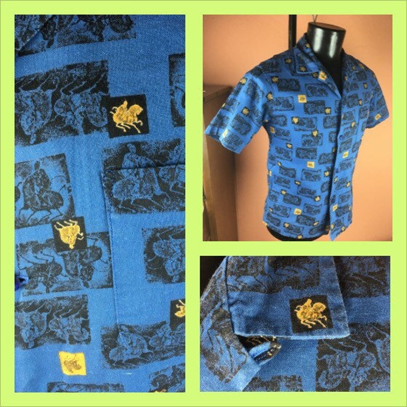 May include: A blue short-sleeved button-up shirt with a repeating pattern of black and gold images. The shirt has a collar and a pocket on the left side.