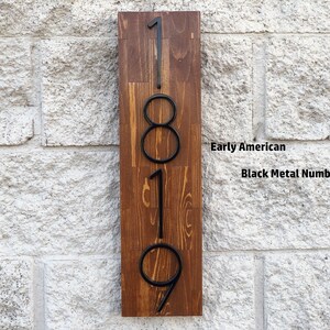 May include: A wooden sign with the numbers 1819 in black metal. The sign is labeled "Early American" and "Black Metal Numbers".