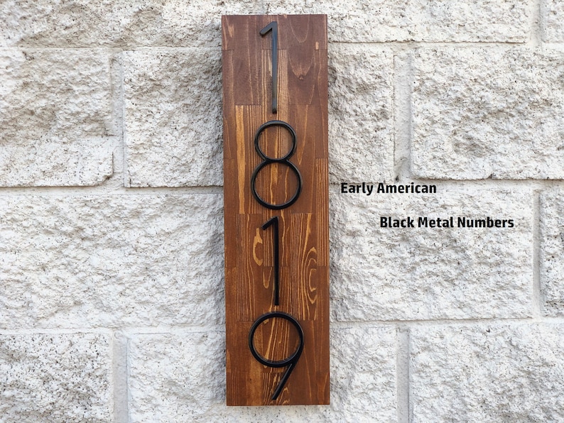 May include: A wooden sign with the numbers 1819 in black metal. The sign is labeled "Early American" and "Black Metal Numbers".
