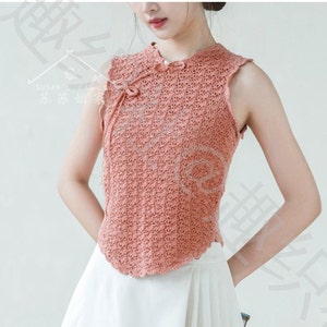 May include: A sleeveless, peach-colored crocheted top with a mandarin collar and a tie at the neckline. The top has a scalloped hem and is made of a delicate, open-weave fabric.