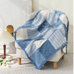 May include: A handmade crochet blanket featuring a patchwork design of alternating square blocks in shades of blue and cream. The blanket displays various intricate openwork patterns, including floral and geometric motifs, with a solid blue border.