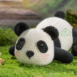 cute crochet panda lying on grassland with tummy facing camera by 45 degree angle, panda having big uprising butt, panda looking at tiny rabbit in front of him, with mountain background