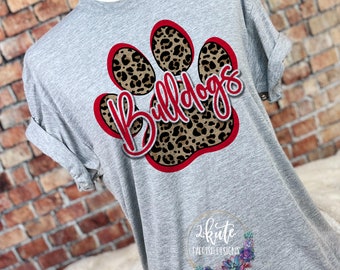 May include: Gray t-shirt with a red and brown leopard print paw print design. The word "Bulldogs" is written in red cursive lettering over the paw print.