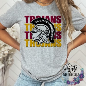 K&ouml;nnte beinhalten: Ein graues T-Shirt mit einem Grafikdesign eines schwarz-wei&szlig;en r&ouml;mischen Helms mit dem Wort "TROJANS" in Rotbraun und Gold wiederholt.