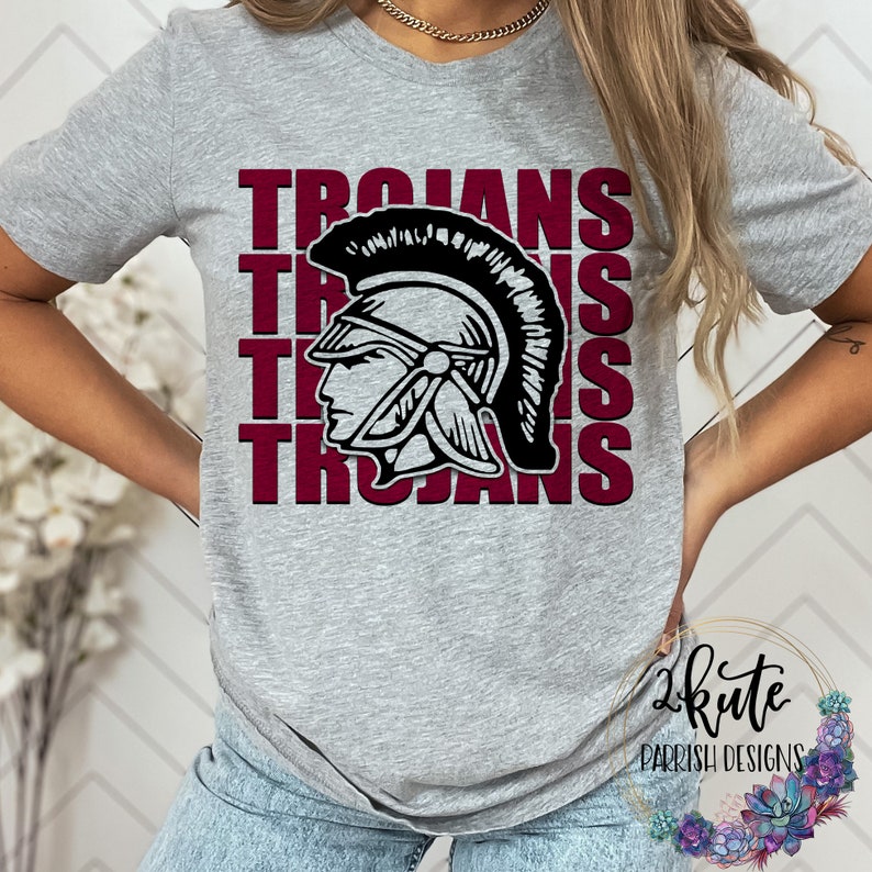 K&ouml;nnte beinhalten: Graues T-Shirt mit einer roten und schwarzen Grafik eines trojanischen Kriegerhelms und dem Wort "Trojans", das viermal wiederholt wird.