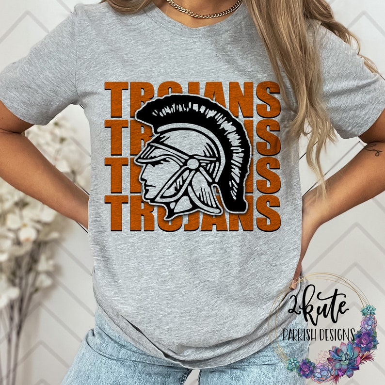 K&ouml;nnte beinhalten: Graues T-Shirt mit dem Wort "TROJANS" viermal in Orange wiederholt. Eine Schwarzwei&szlig;illustration eines trojanischen Kriegerhelms ist mittig auf dem T-Shirt platziert.