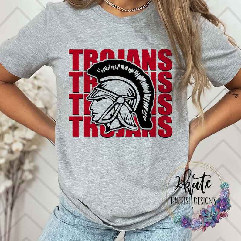 K&ouml;nnte beinhalten: Graues T-Shirt mit einer roten und schwarzen Grafik eines Trojanerhelms und dem Wort "Trojans", das viermal wiederholt wird.