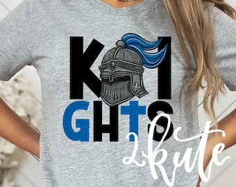 May include: A gray t-shirt with black and blue lettering that reads "Knights 2 Kute". The lettering is decorated with a knight's helmet with a blue plume.