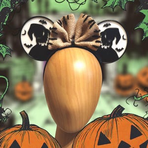 K&ouml;nnte beinhalten: Schwarze und wei&szlig;e M&auml;useohren mit einer Schleife aus Sackleinen. Die Ohren zeigen eine Silhouette von Jack Skellington aus Nightmare Before Christmas.