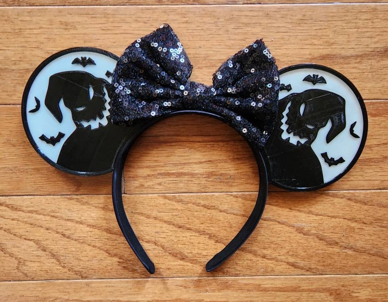 K&ouml;nnte beinhalten: Schwarz-wei&szlig;e M&auml;useohren mit einer Silhouette von Jack Skellington aus Nightmare Before Christmas. Die Ohren haben eine schwarze Pailletten Schleife.