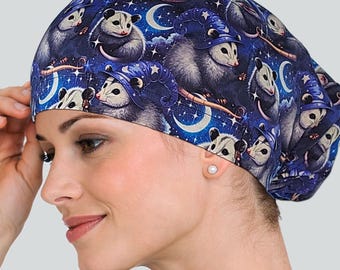 May include: A dark blue surgical scrub cap featuring a repeating pattern of opossums wearing wizard hats, moons, and stars. The cap is made of a soft fabric and is designed to be worn in a medical setting.