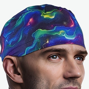 May include: A patterned head covering featuring a vibrant galaxy design in shades of blue, purple, green, and pink. The fabric is wrapped around the head, creating a comfortable fit. The head covering is a stylish accessory.