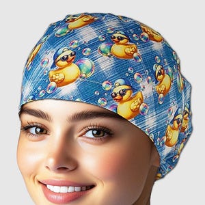 May include: A blue scrub cap featuring a pattern of yellow rubber ducks wearing sunglasses and floating in bubbles. The cap has a plaid background and is designed for medical professionals or those in the healthcare field.