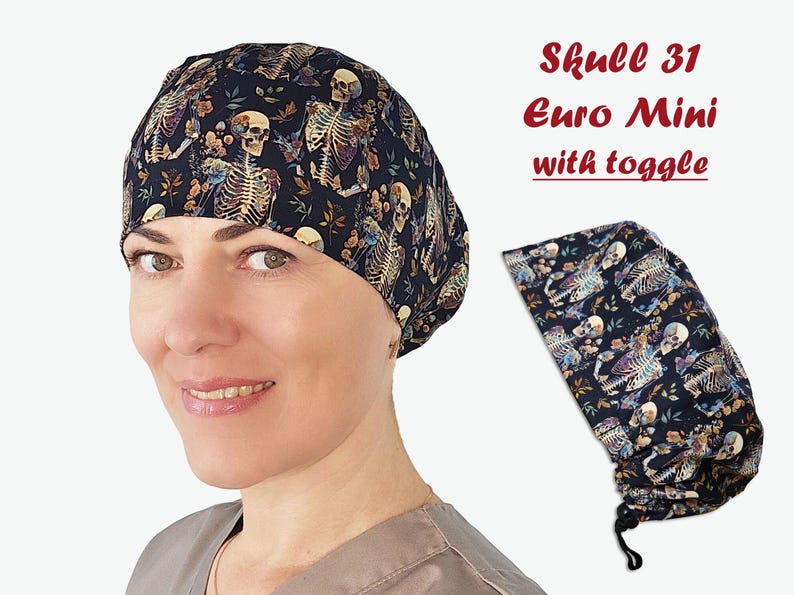 Puede incluir: Un gorro quir&uacute;rgico azul oscuro con un patr&oacute;n repetido de esqueletos y elementos florales. El gorro se muestra en una persona y tambi&eacute;n se muestra por separado. El texto "Skull 31 Euro Mini with toggle" es visible.