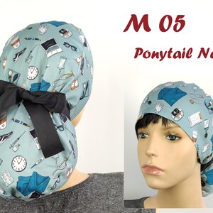 May include: A light blue medical scrub cap with a black bow. The cap is patterned with medical equipment and supplies. Text on the image reads "M 05 Ponytail New".