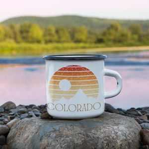 Born to be in the Great Outdoors, this custom Retro Colorado Sunset enameled camp mug is an outdoor lovers best sidekick. With 12oz for your favorite beverage, these camping mugs are made of metal, making them a hard-wearing choice for any adventure.