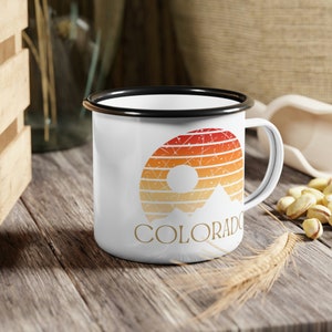 Born to be in the Great Outdoors, this custom Retro Colorado Sunset enameled camp mug is an outdoor lovers best sidekick. With 12oz for your favorite beverage, these camping mugs are made of metal, making them a hard-wearing choice for any adventure.