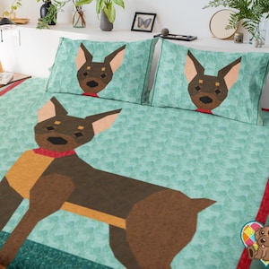 May include: A teal dog-themed bedding set featuring a large geometric dog design on the comforter and pillowcases. The dog is brown, tan, and black with a red collar. The set has a red border.