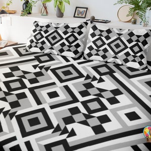 Puede incluir: Bedding con estampado geométrico en blanco y negro con dos fundas de almohada a juego. El patrón presenta cuadrados, rectángulos y triángulos.
