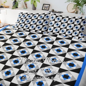May include: A black and white quilt pattern with blue accents. The pattern is a geometric design of squares and triangles. The quilt is on a bed with blue pillowcases. The text "Monkey Wrench Quilt Pattern downloadable pdf" is written on the quilt.