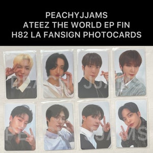 May include: Eight photo cards featuring members of the K-pop group Ateez. The cards are white with a light blue background and feature the group members in various poses. The cards are part of a fansign event for the group's album "The World EP. Fin".