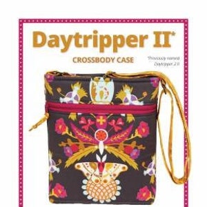 May include: A Daytripper II crossbody case sewing pattern featuring a colorful floral print with a butterfly design. The pattern includes instructions for making a crossbody bag with an adjustable strap and easy-to-install zippers. The text on the pattern reads "Daytripper II Crossbody Case" and "The perfect travel companion!"