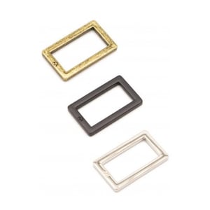 Puede incluir: Tres anillos rectangulares de metal en dorado, negro y plateado.