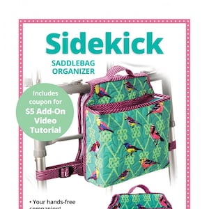 Może przedstawiać: Turkusowy i różowy organizer do siodła z nadrukiem ptaków i wieloma kieszeniami. Organizer jest przymocowany do chodzika. Tekst "Sidekick" znajduje się w górnej części obrazu. Tekst "Szybki i łatwy dostęp do niezbędnych rzeczy na dzień!" znajduje się w dolnej części obrazu.