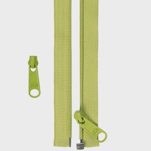 May include: Close-up of a lime green zipper with a matching zipper pull. The zipper is shown both open and closed, with the pull detached. The zipper teeth are a darker shade of green.