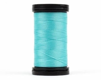 May include: A spool of turquoise thread with black plastic caps on either end.