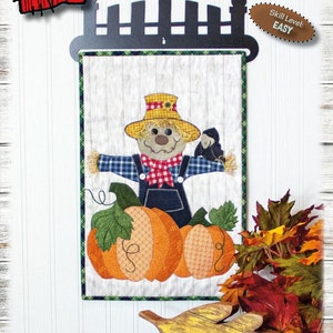 Könnte beinhalten: Ein Patchwork-Quiltblock mit einem Vogelscheuchen-Motiv, das einen Strohhut, ein kariertes Hemd und eine Latzhose trägt und auf zwei Kürbissen sitzt. Der Block ist mit einem schwarzen Metallzaun gerahmt und trägt den Text "NOT SO, SCARECROW" und "12" x 18" darüber. Der Schwierigkeitsgrad ist mit "EASY" angegeben.