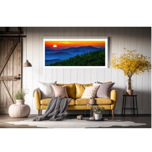 Puede incluir: Una fotograf&iacute;a enmarcada de una puesta de sol sobre una cordillera. El cielo es de un naranja y amarillo vibrantes, con monta&ntilde;as azules en la distancia. El sol se pone detr&aacute;s de las monta&ntilde;as, proyectando un c&aacute;lido resplandor sobre la escena.