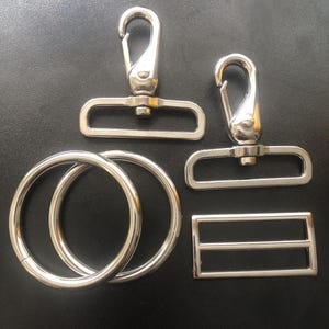 May include: A set of three ceramic mugs with a speckled, matte finish. The mugs are in shades of cream, light gray, and dark gray. Each mug has a simple, minimalist design and a rounded handle.