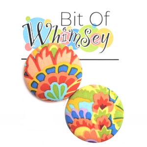 May include: A pair of colorful fabric button earrings with a paisley pattern in shades of red, orange, yellow, green, blue, and purple.